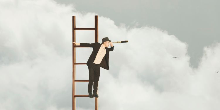 Person dressed in black suit and white shirt at the top of a ladder looking through a telescope, with clouds in the background