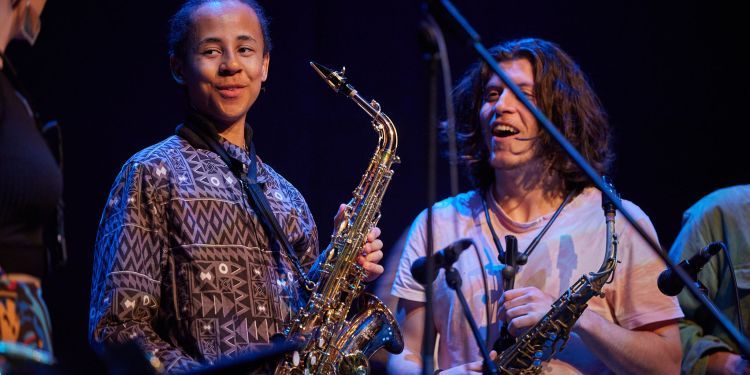 Students smiling holding saxophone