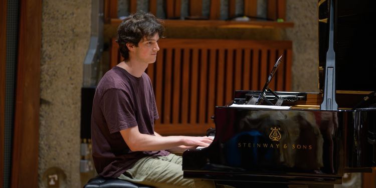 Student sat at the piano playing