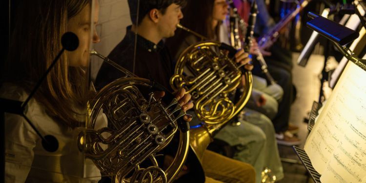 Two students playing the french horn