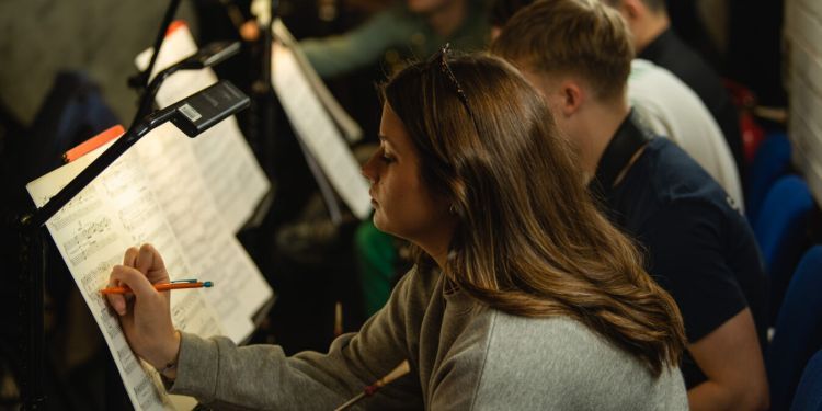 Female student making notes on sheet music