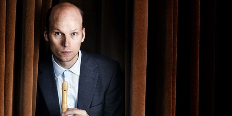 Erik Bosgraaf holding his recorder in between curtains