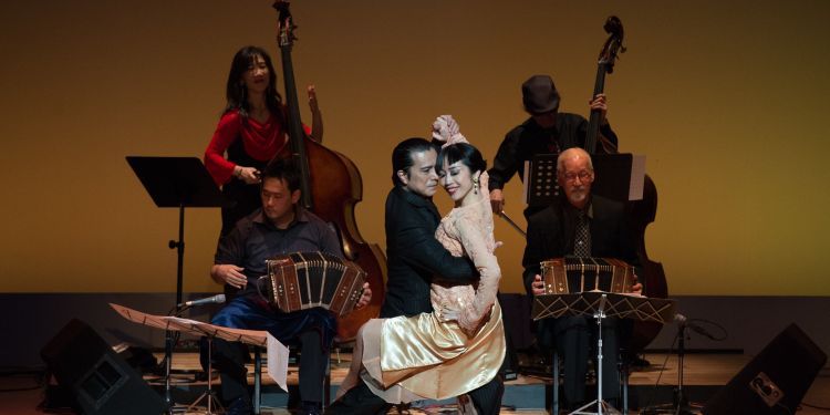 Two dancers on stage performing a lift as part of a Tango routine