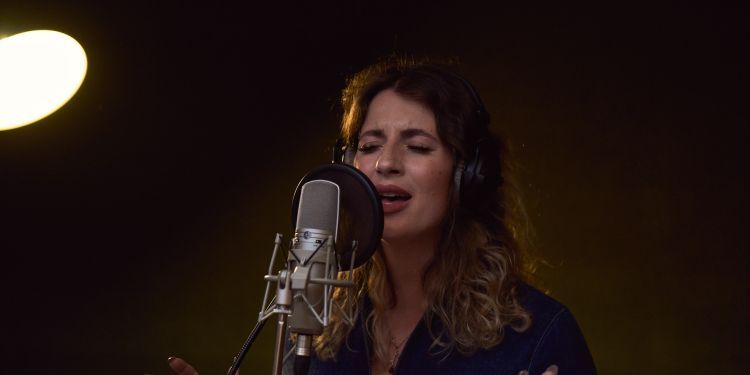 Emma Smith performs behind a microphone
