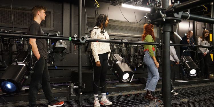 Three students standing on the tension wire grid at Guildhall School of Music and Drama.