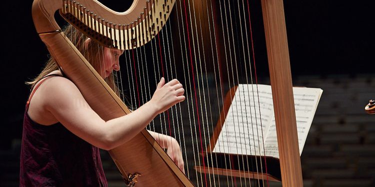 Harpist performing in front of music score