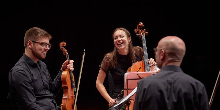 Chamber musicians laughing on stage 