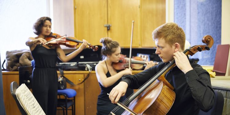 Three students practicing - cello and violin