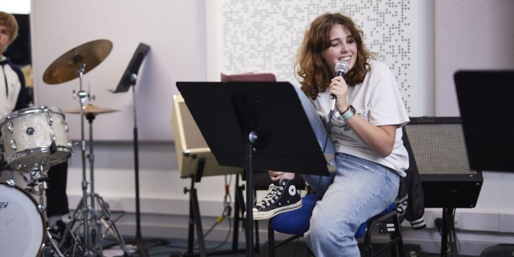 Girl smiling and singing with a microphone