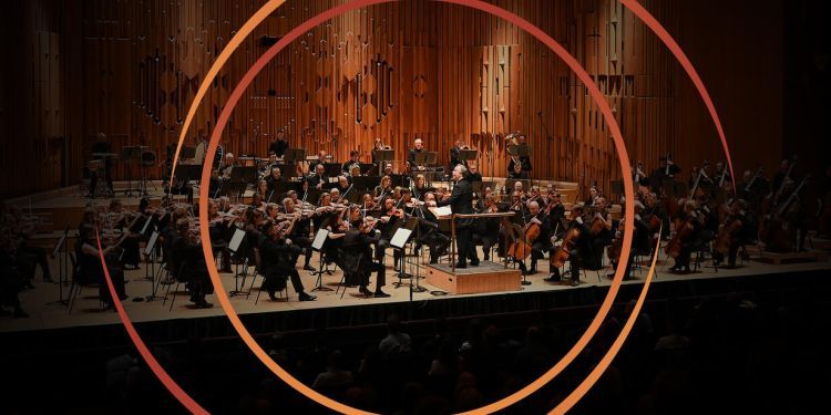 Orchestra on stage at Barbican Hall with circle graphics surrounding image