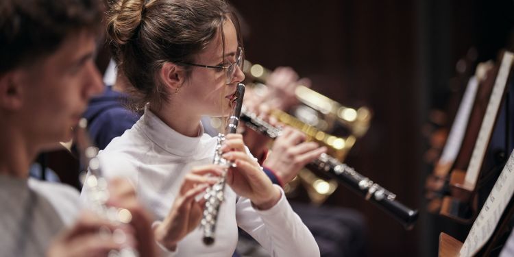 Flautist performing in woodwind section of orchestra