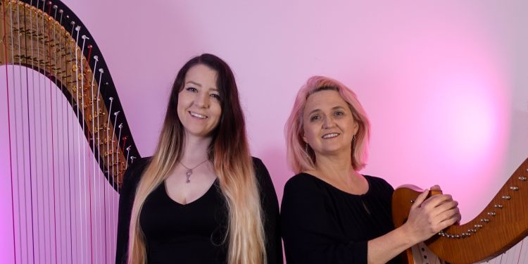 Amy Turk and Lauren Scott holding their harps