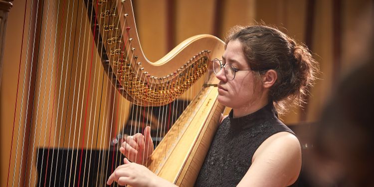 Student playing harp