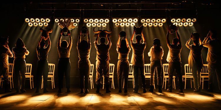 Silhouettes of actors holding masks up to lights