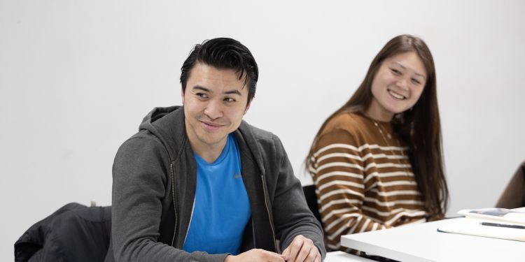 Participants sitting at desk smiling 