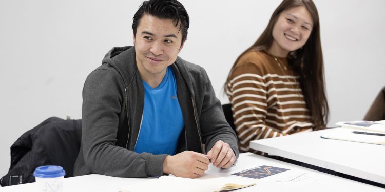 Participants sitting at desk smiling