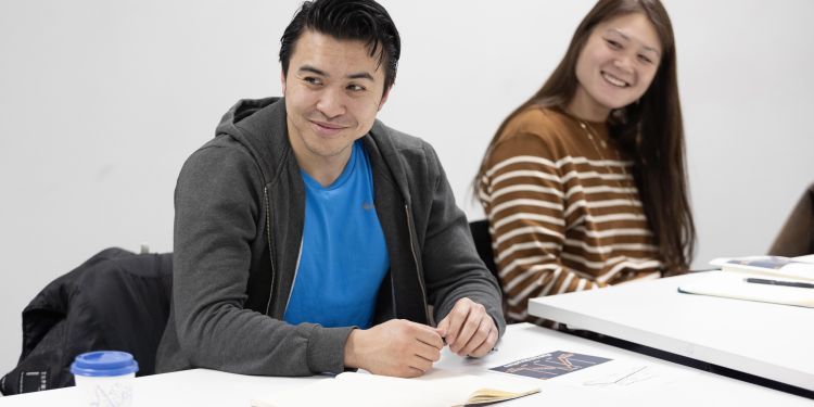 Participants sitting at desk smiling 