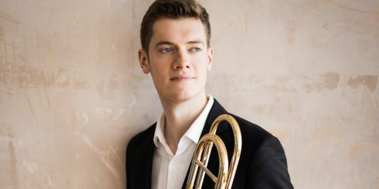Headshot of Peter Moore holding trombone