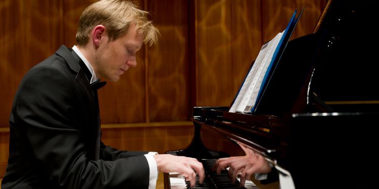 Student in formal attire playing piano