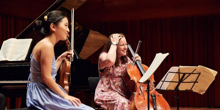 Two students on stage with a violin and cello
