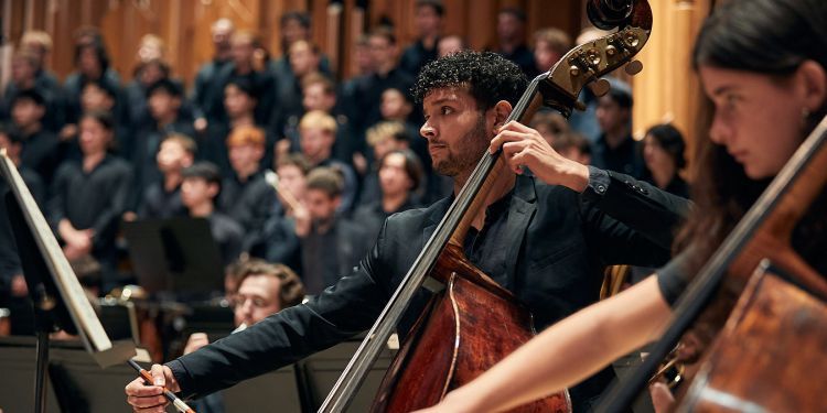 Double bassists in front of choir