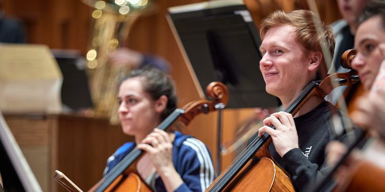 Two students playing the cello