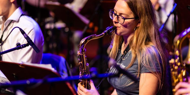 Jazz musician playing saxophone with an ensemble
