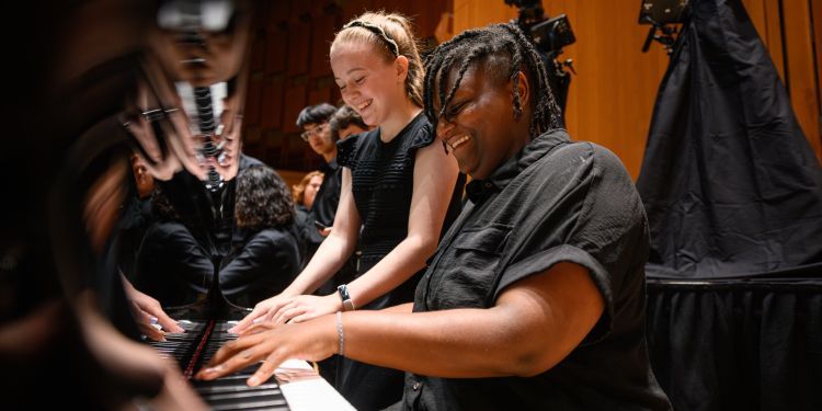 LSSO students on stage sat at the piano