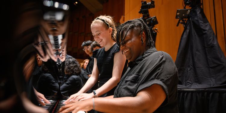 LSSO students on stage sat at the piano