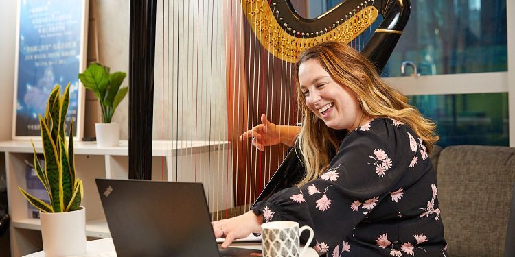 Student playing harp whilst teaching online