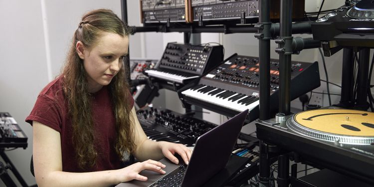 Student at a sound desk and piano