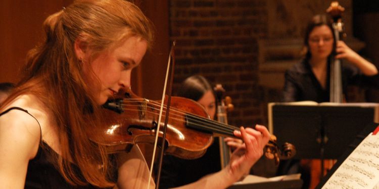 Student playing violin on stage