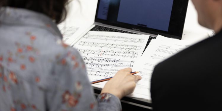 participant sitting at desk looking at manuscript paper