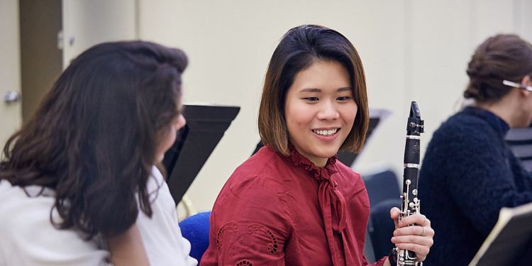 Student smiling whilst holding their clarinet