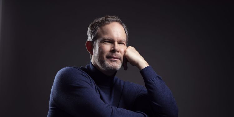 Gerald Finley sitting on chair with hand on face