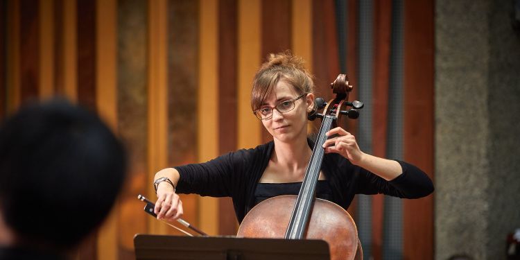 Student playing cello on stage