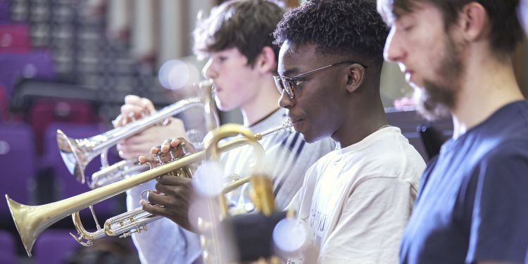 Junior students playing brass instruments in rehearsal