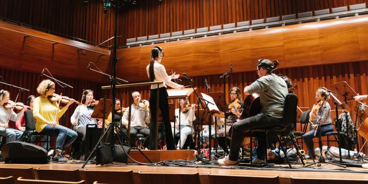 Female muscian conducting an orchestra