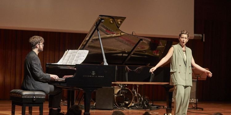 Singer on stage performing with a pianist