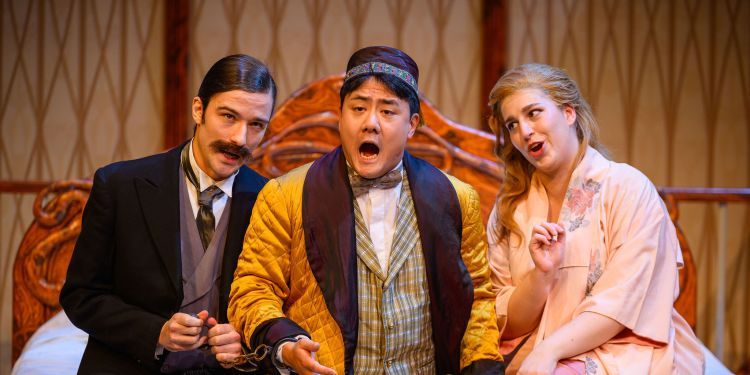 Three students on stage performing during the opera production Die Fledermaus