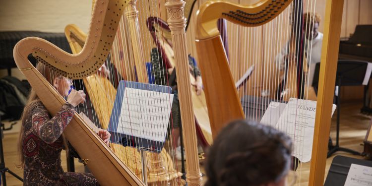 Students rehearsing in a harp class