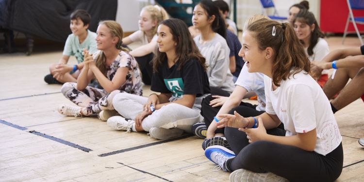 Participants sitting in a room smiling and listening to the course tutor