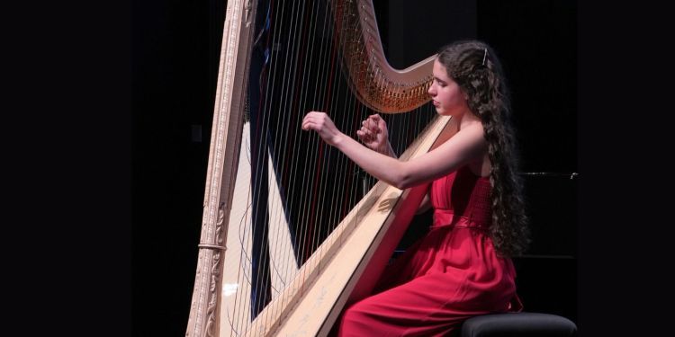 Teodora Cotuna Rizea in red dress playing harp