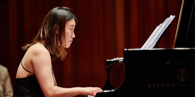 Student pianist on stage performing 
