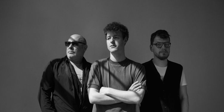 Black and white image of the Fabian Willmann Trio standing smiling next to one another