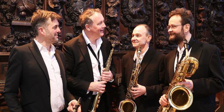 Quartz Saxophone Quartet in suits smiling at each other