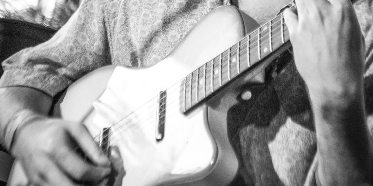 Black and white photo of person playing electric guitar