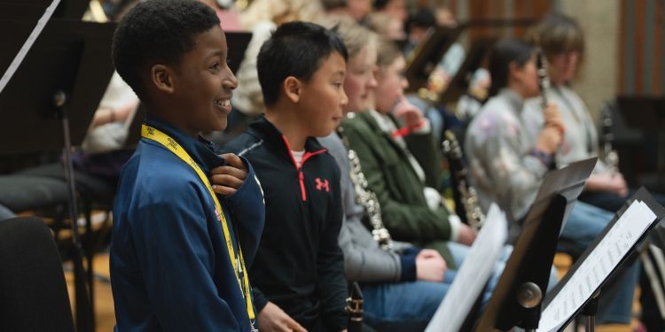 A row of young musicians holding their clarinets