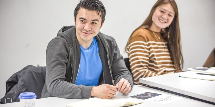 Two participants with notebooks in front of them, smiling