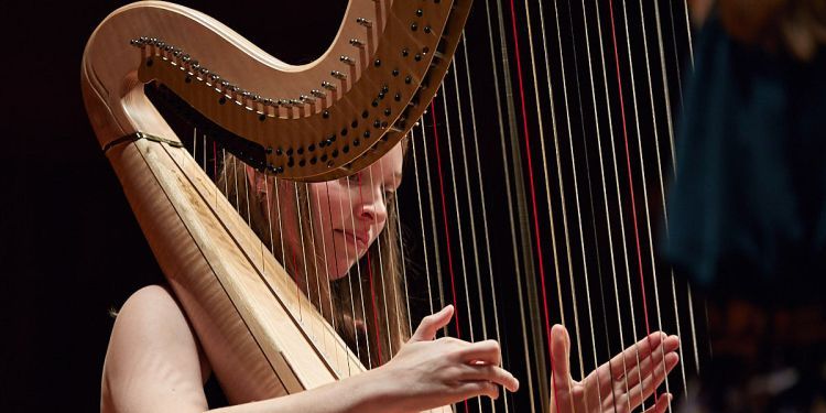 Harp student on stage performing
